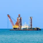 dredging-ship-is-bucketing-mud-coastline-maintain-water-level-large-vessel-transportation-while-destroying-marine-habitat-shoreline